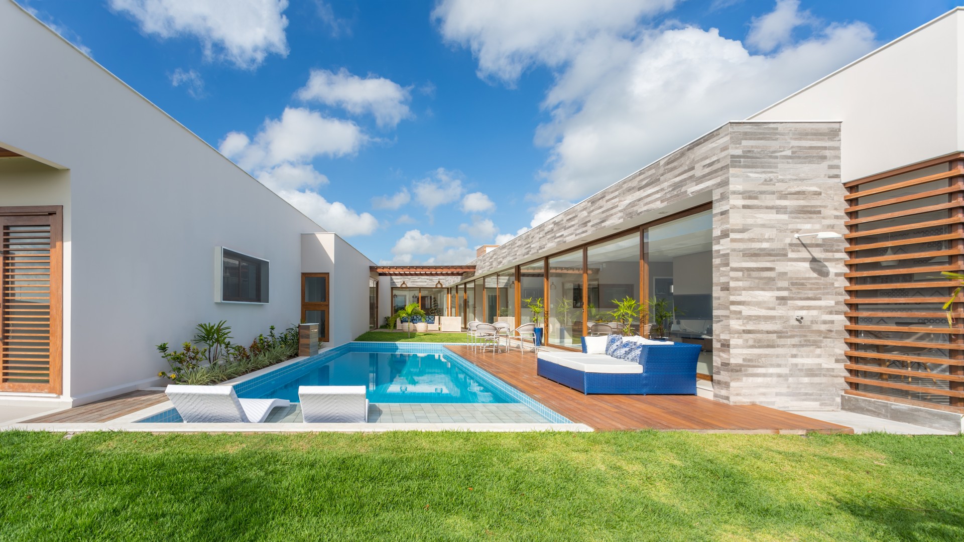 À direita, o volume das áreas comuns, à esquerda, o volume das áreas privativas. A prainha da piscina e o deck se conectam ao grande jardim, criando uma relação agradável entre interior e exterior. Ambos adquirem uma forma reta em referência às linhas ortogonais dos volumes da casa.