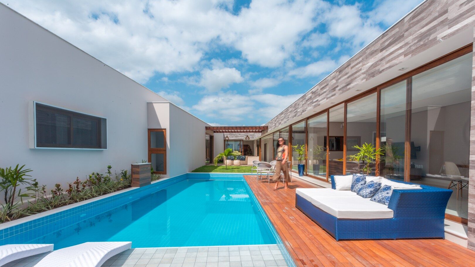 À direita, o volume das áreas comuns, à esquerda, o volume das áreas privativas. A prainha da piscina e o deck se conectam ao grande jardim, criando uma relação agradável entre interior e exterior. Ambos adquirem uma forma reta em referência às linhas ortogonais dos volumes da casa.